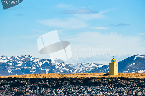 Image of Lighthouse in a landscape with mountains