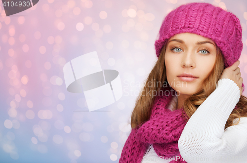 Image of woman in hat and scarf over pink lights background