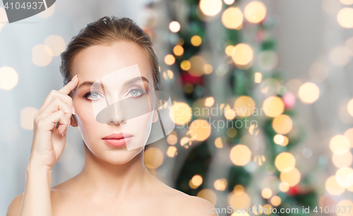 Image of beautiful woman face over christmas lights