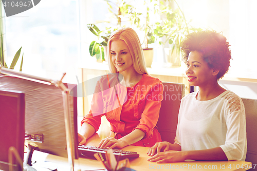 Image of happy women or students with computer in office