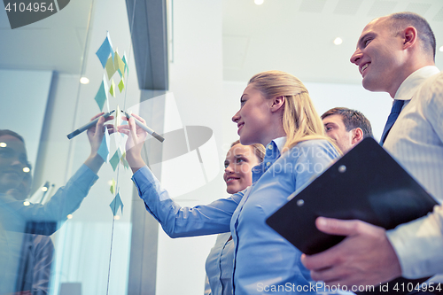 Image of smiling business people with marker and stickers