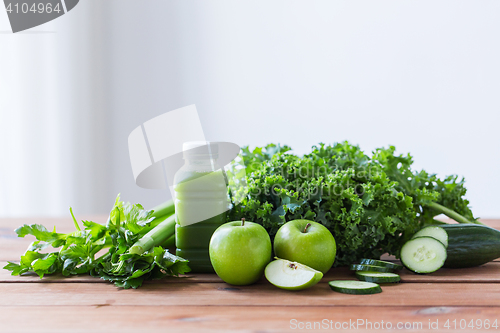 Image of close up of bottle with green juice and vegetables