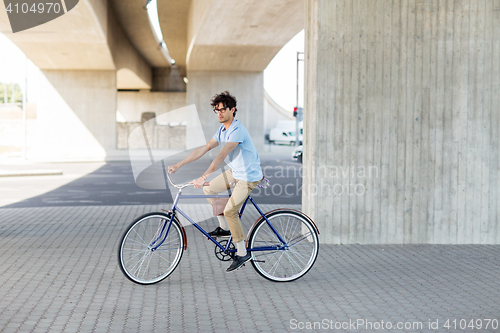 Image of young hipster man riding fixed gear bike