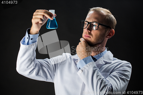 Image of young scientist holding test flask with chemical
