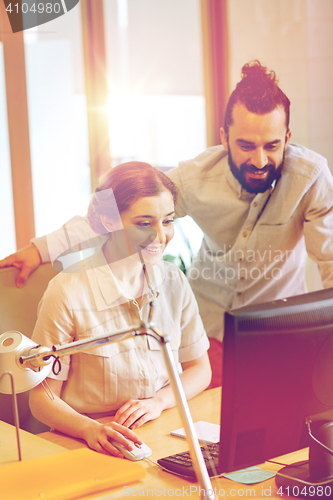 Image of happy creative team with computer in office