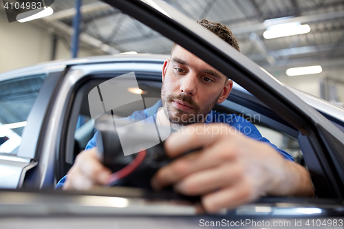 Image of mechanic man with diagnostic scanner at car shop