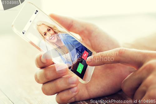 Image of close up of male hand with transparent smartphone