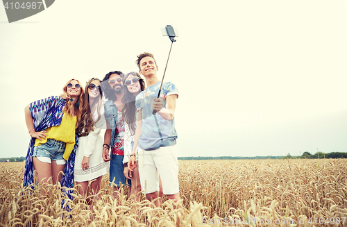 Image of hippie friends with smartphone on selfie stick