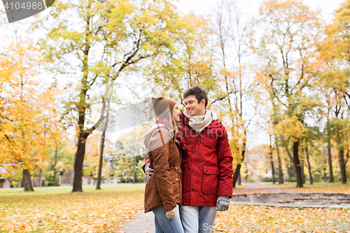 Image of happy young couple walking in autumn park