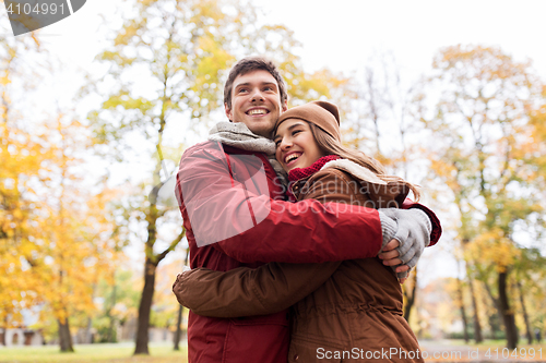 Image of happy young couple hugging in autumn park