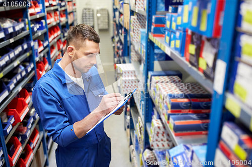 Image of auto mechanic with clipboard at car workshop