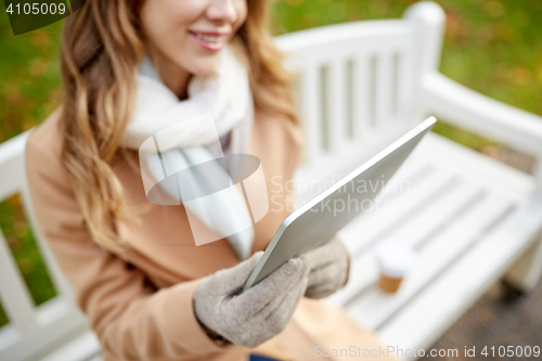 Image of close up of woman with tablet pc in autumn park