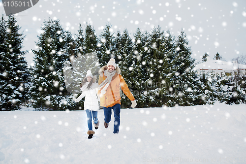 Image of happy couple running in winter snow