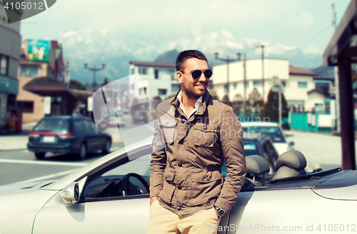 Image of happy man near cabriolet car over city in japan