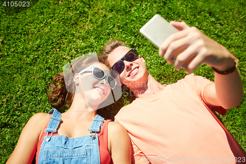 Image of happy couple taking selfie on smartphone at summer