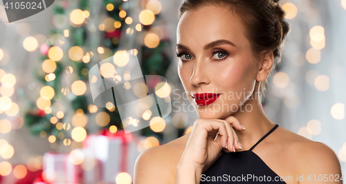 Image of beautiful woman in black over dark background