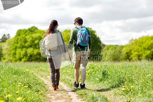 Image of happy couple with backpacks hiking outdoors