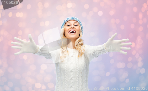 Image of happy young woman in winter hat and sweater