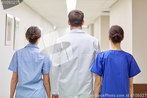 Image of group of medics or doctors walking along hospital