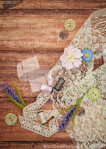 Image of Lace and thread on wooden background