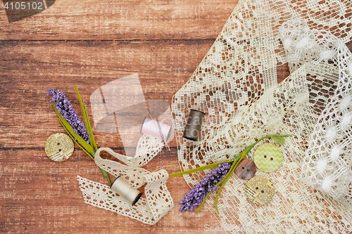 Image of Lace and thread on wooden background