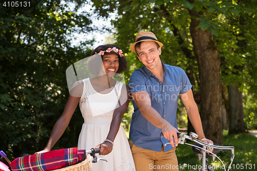 Image of Young multiethnic couple having a bike ride in nature
