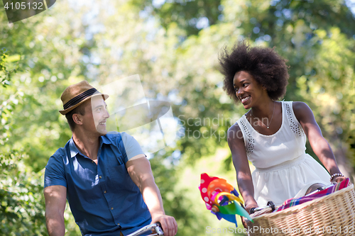 Image of Young multiethnic couple having a bike ride in nature