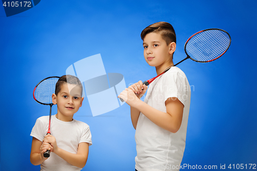 Image of The two boys with  badminton rackets outdoors