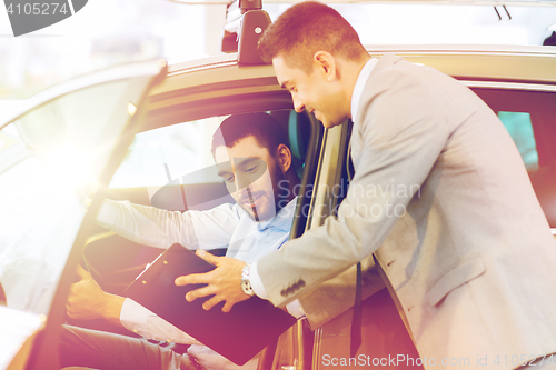 Image of happy man with car dealer in auto show or salon