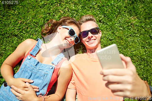 Image of happy couple taking selfie on smartphone at summer