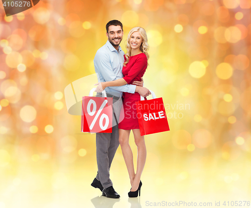 Image of happy couple with red shopping bags