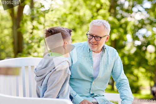 Image of grandfather and grandson talking at summer park