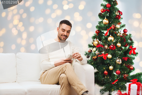 Image of smiling man with smartphone for christmas
