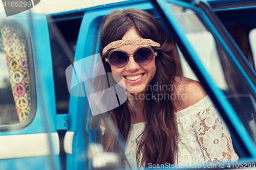 Image of smiling young hippie woman in minivan car