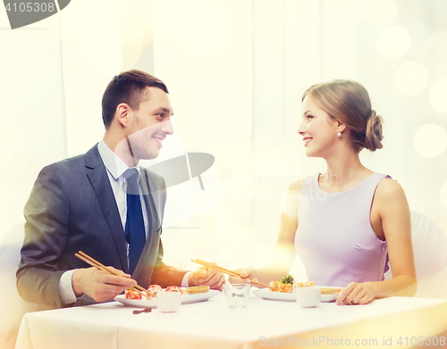Image of smiling couple eating sushi at restaurant