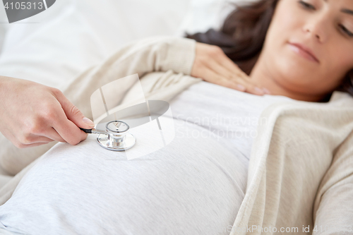 Image of doctor with stethoscope and pregnant woman