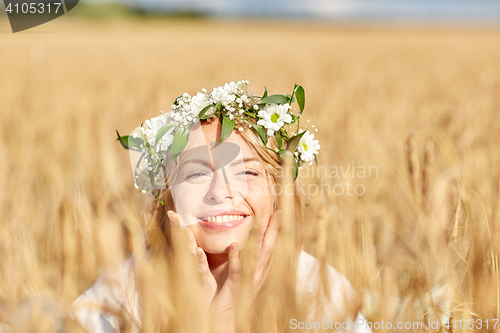 Image of happy woman in wreath of flowers on cereal field