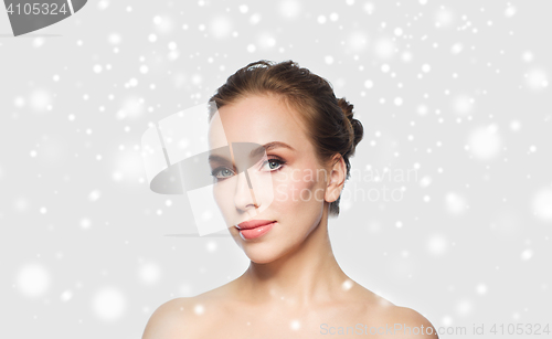 Image of beautiful young woman face over snow