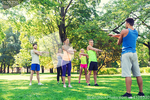 Image of group of friends or sportsmen exercising outdoors