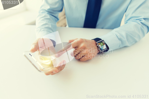 Image of close up of hands with smart phone and watch