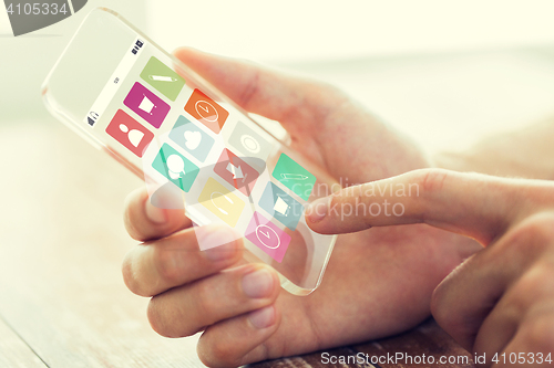 Image of close up of hand with menu icons on smartphone