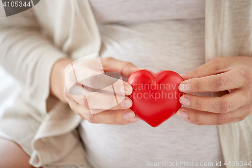Image of close up of pregnant woman with red heart