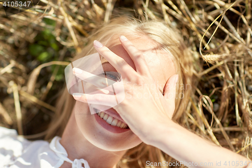 Image of happy young woman lying on cereal field