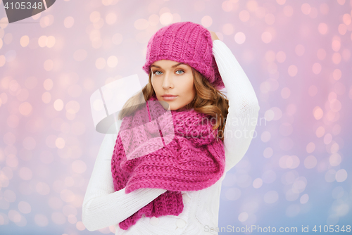 Image of woman in hat and scarf over pink lights background