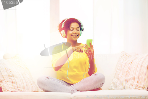 Image of happy african woman with smartphone and headphones