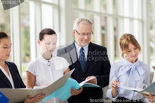 Image of business team with tablet pc and folders at office