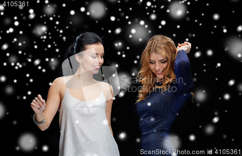 Image of happy young women dancing at night club disco