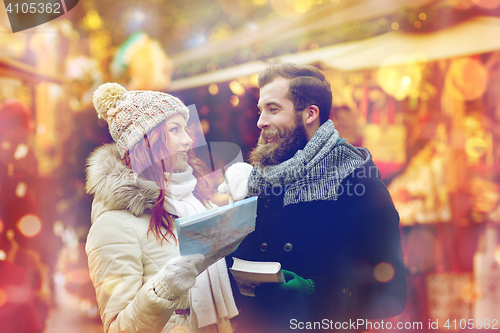 Image of happy couple with map and city guide in old town