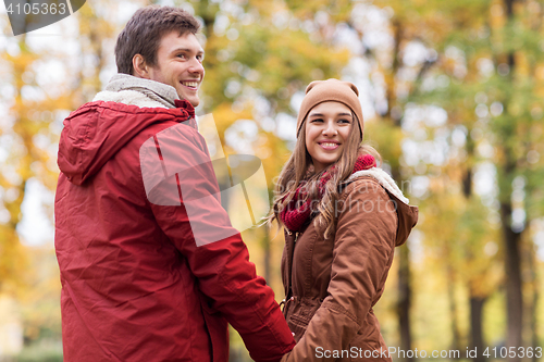 Image of happy young couple walking in autumn park