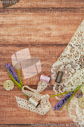 Image of Lace and thread on wooden background